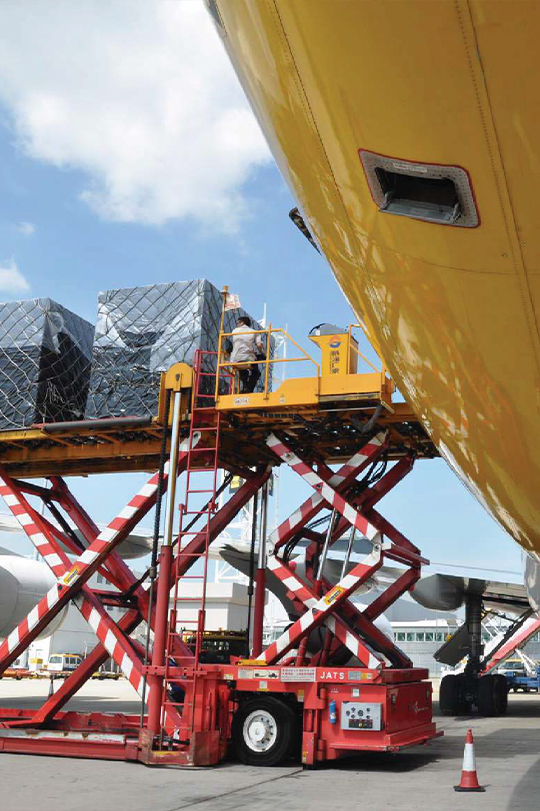 High-loader cargo handling equipment transferring air freight to aircraft for ground support operations at the airport