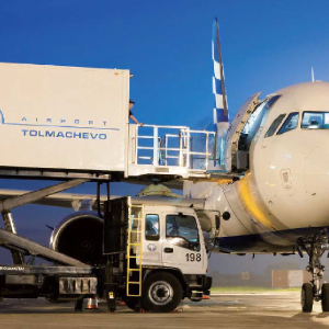 Aircraft catering truck docked at airplane door for meal service at Tolmachevo Airport during ground support operations